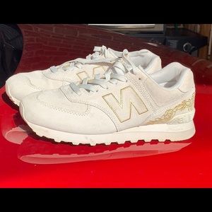 Women’s New Balance 574 with Gold accents.
